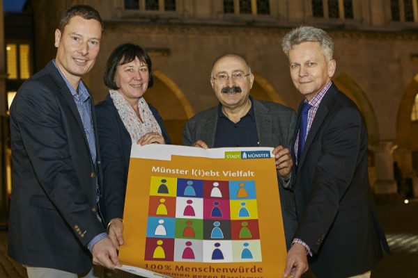 Gruppenbild mit "Wochen gegen Rassismus"-Plakat