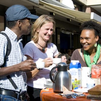 Drei lachende Menschen an einem Kaffeetisch. (Foto: Presseamt Münster / Angelika Klauser)