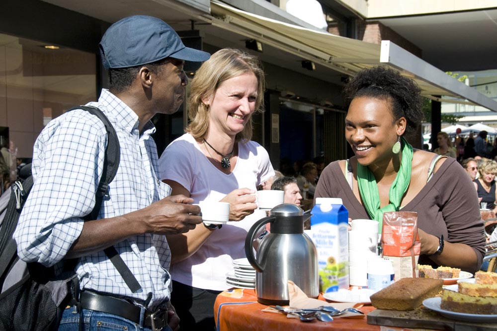 Drei lachende Menschen an einem Kaffeetisch. (Foto: Presseamt Münster / Angelika Klauser)